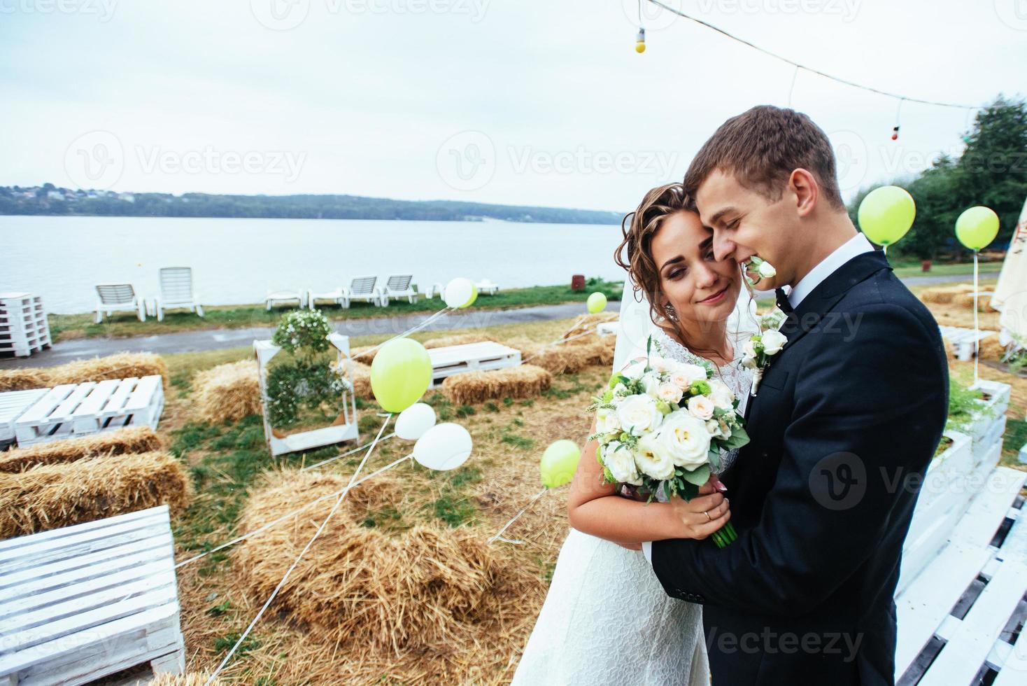 beautiful young wedding couple kissing , blonde bride with flowe photo