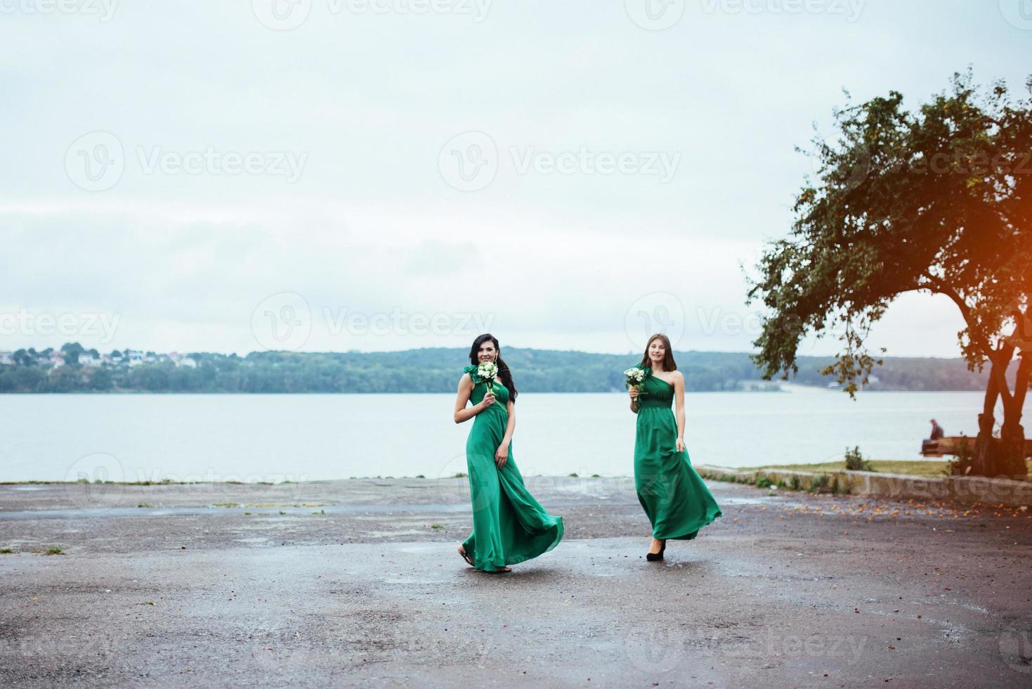 Happy young women at a wedding with bouquets of flowers photo