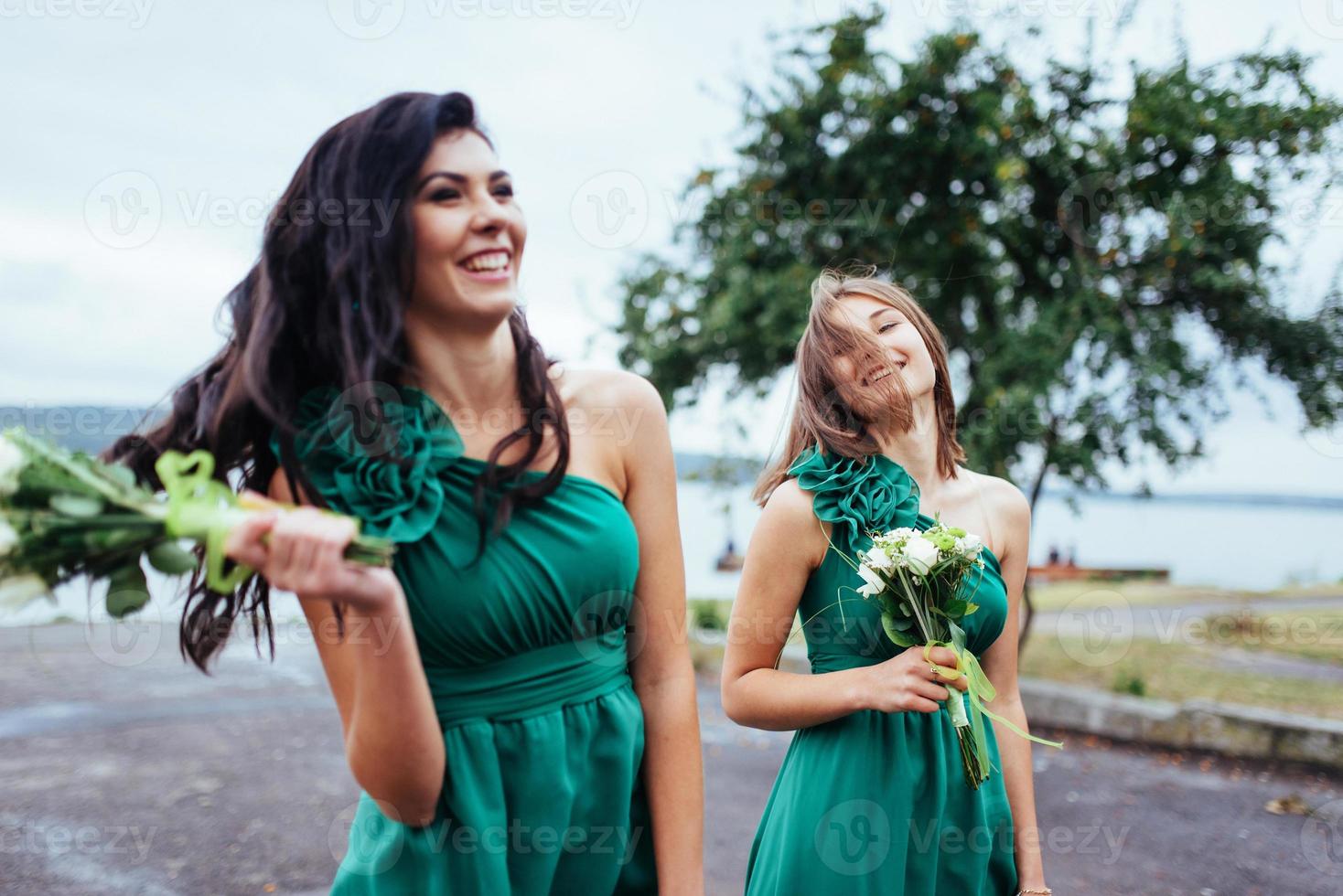 Happy young women at a wedding with bouquets of flowers photo