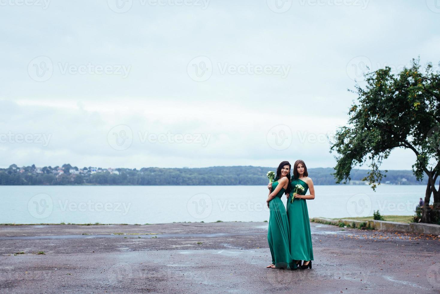 Happy young women at a wedding with bouquets of flowers photo