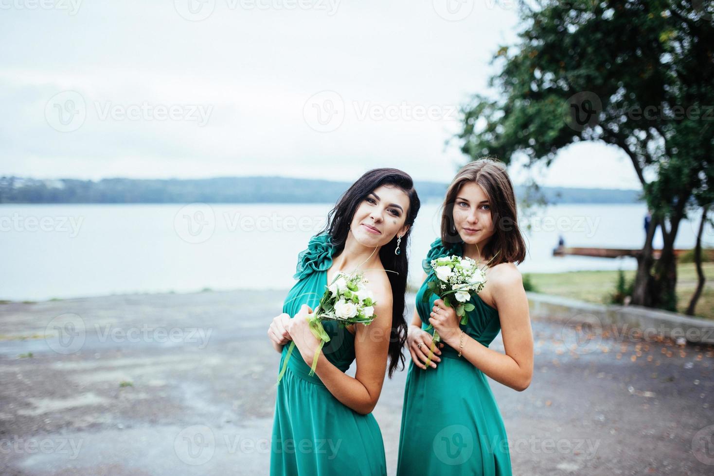 Happy young women at a wedding with bouquets of flowers photo