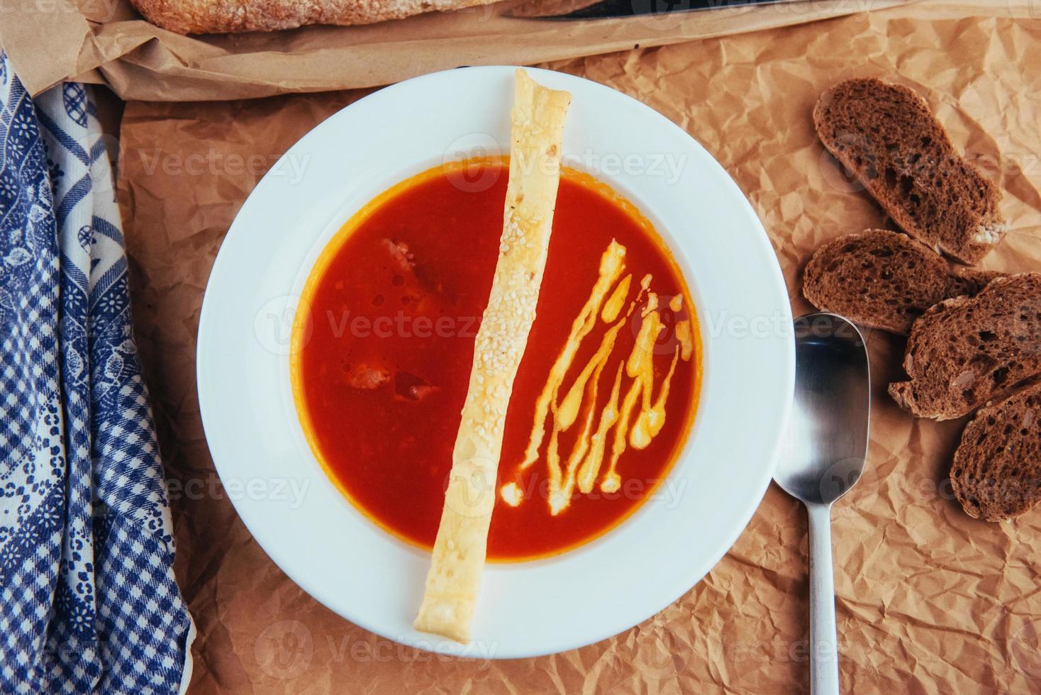 Fresh tomato soup in a white mask with bread baguette photo