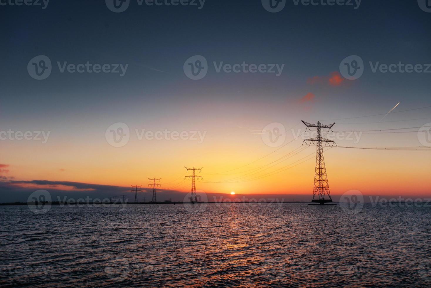 electric line above water during a fantastic sunset. photo