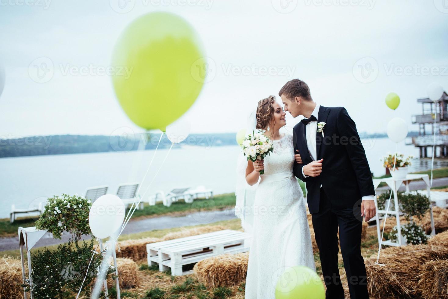 beautiful young wedding couple kissing , blonde bride with flowe photo