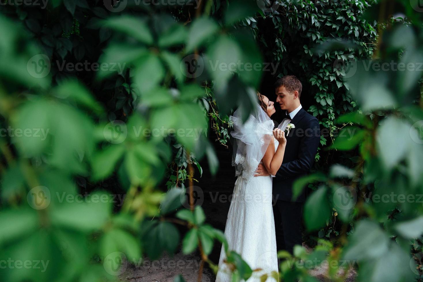 beautiful young wedding couple kissing , blonde bride with flowe photo