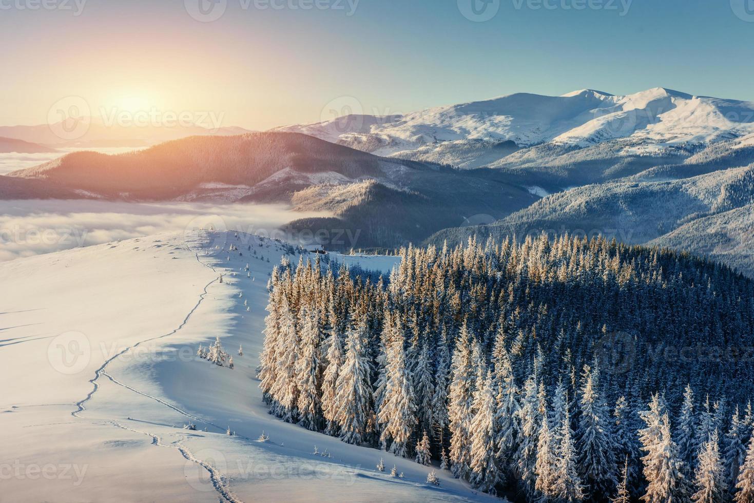 Fantastic winter landscape and worn trail leading into the mount photo