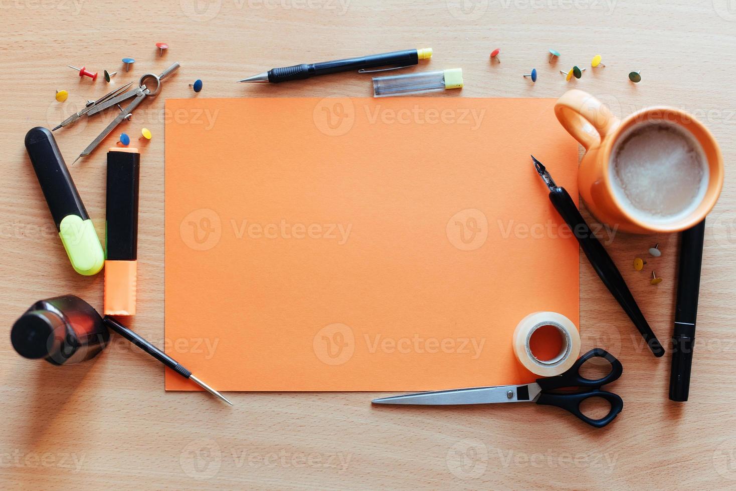 hoja vacía de color naranja con un montón de objetos de papelería hace foto