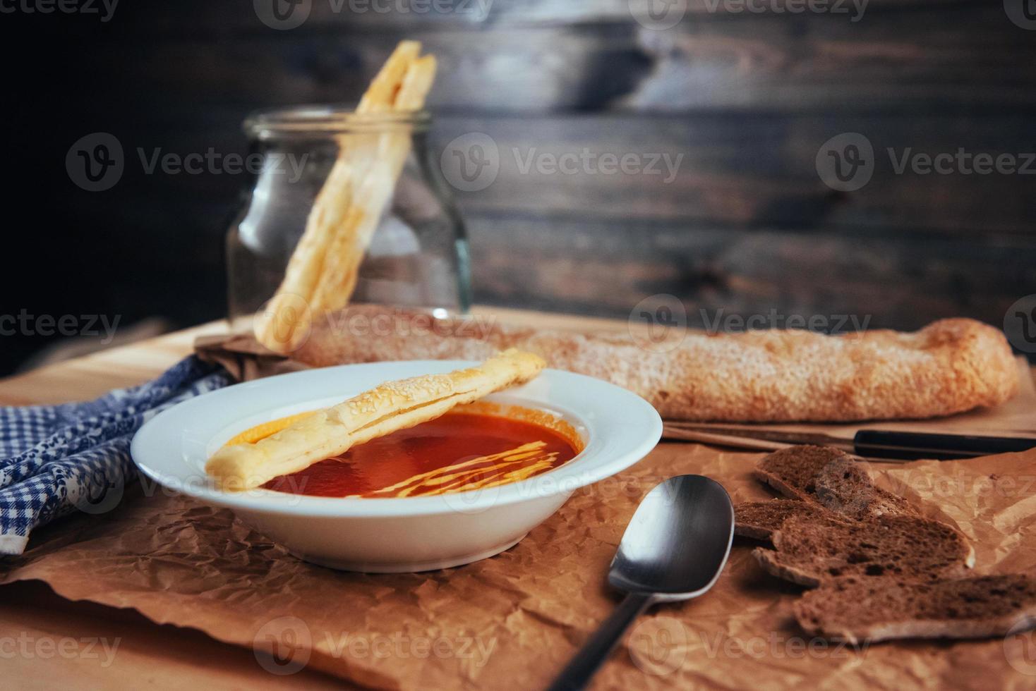 Fresh tomato soup in a white mask with bread baguette photo