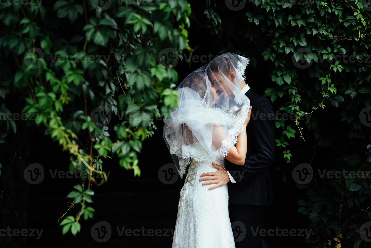 Young bride hugging her groom in beautiful park photo