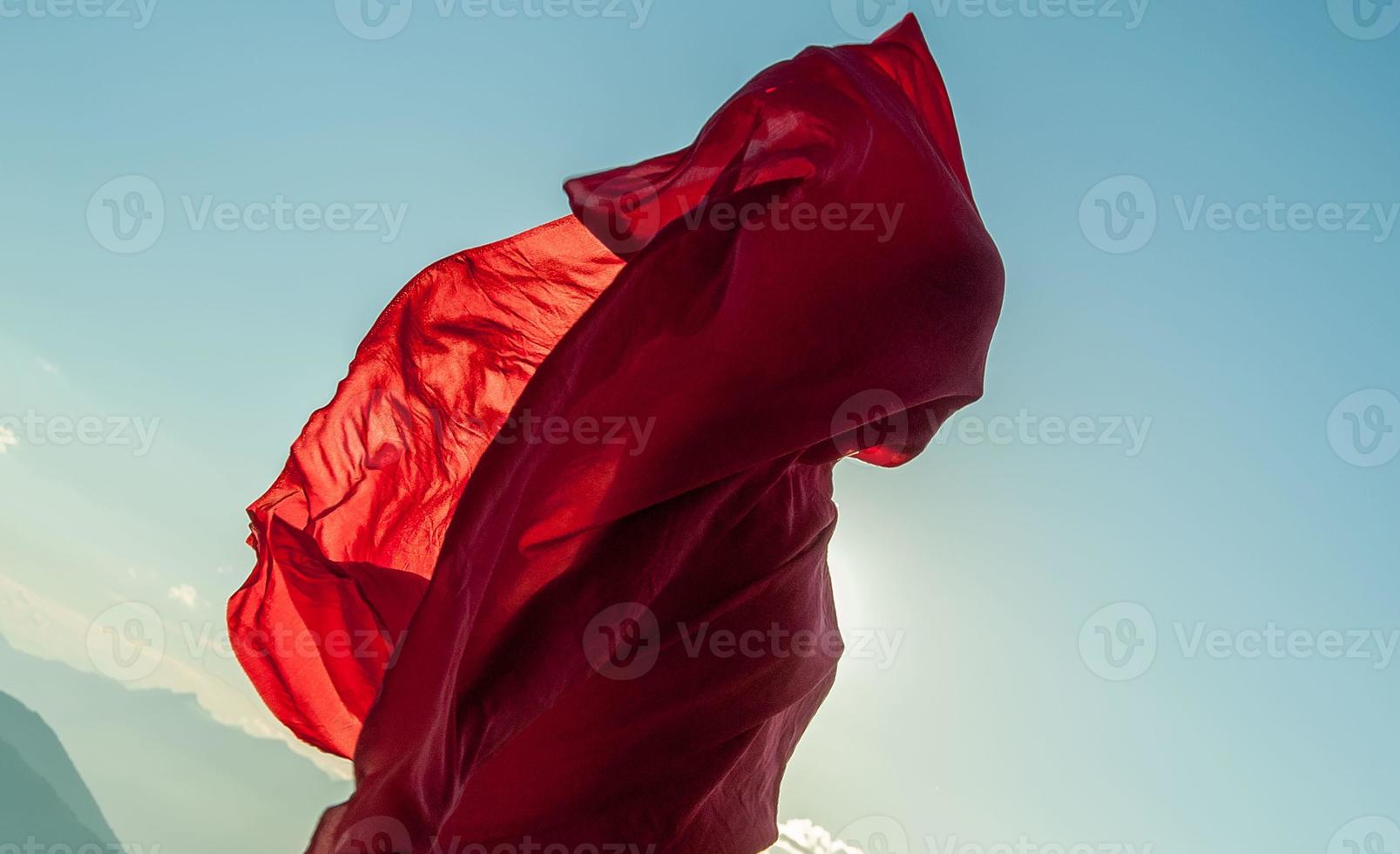 Woman wrapped in a red scarf in the wind photo