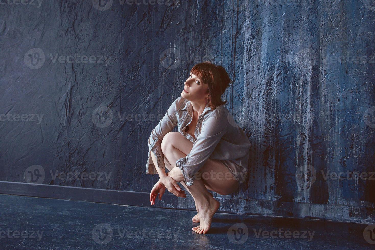 psychological emotional portrait of upset woman near the wall photo