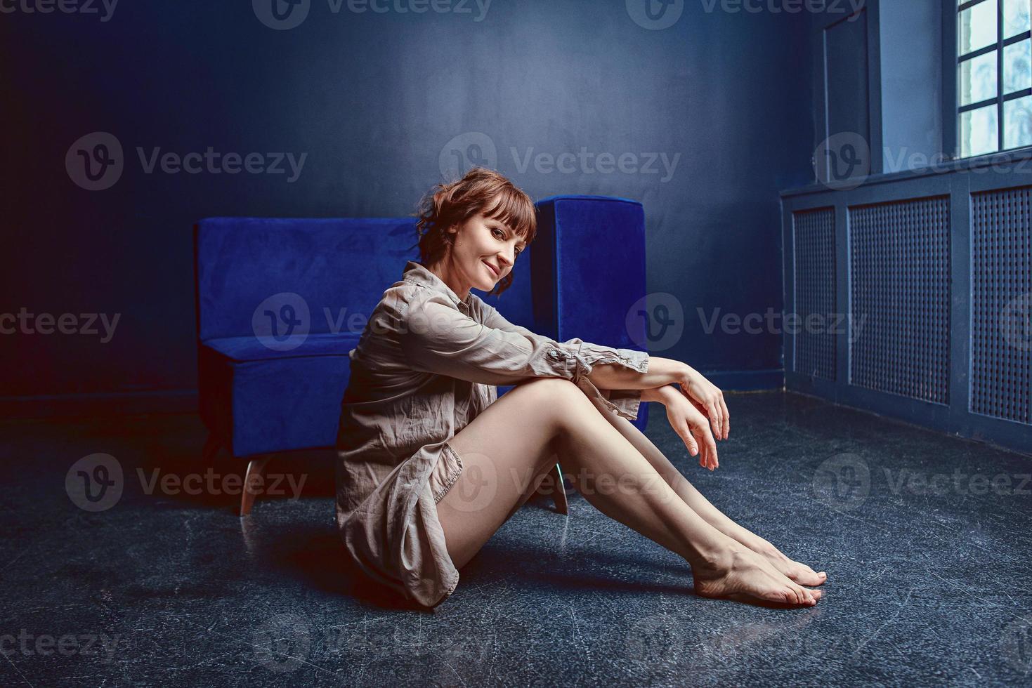 beautiful relaxed woman at home interior near the blue sofa photo