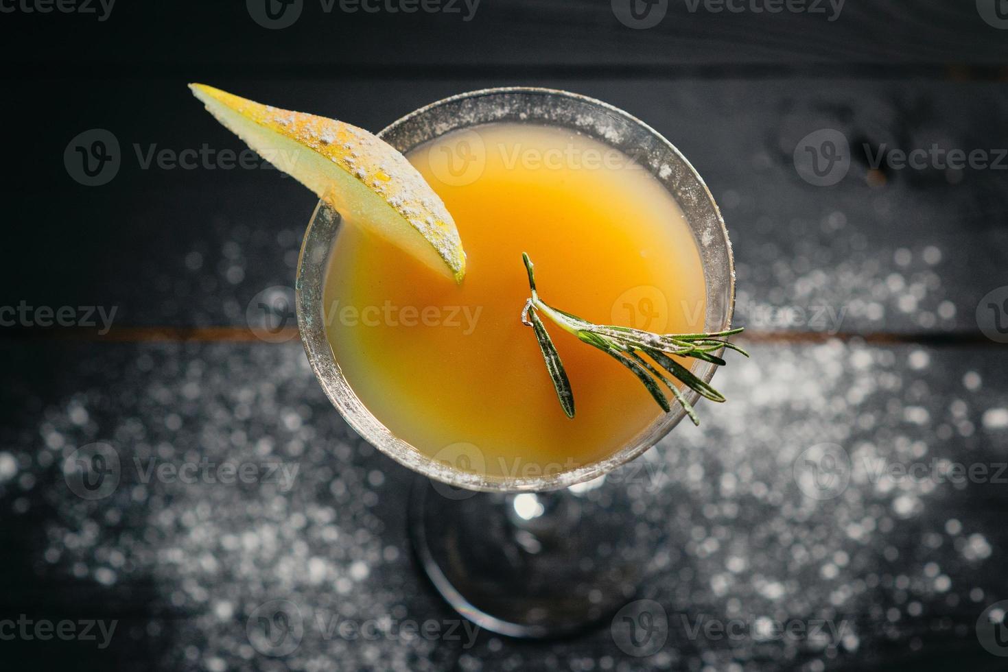 cóctel de pera de alcohol amarillo pera sobre fondo oscuro foto