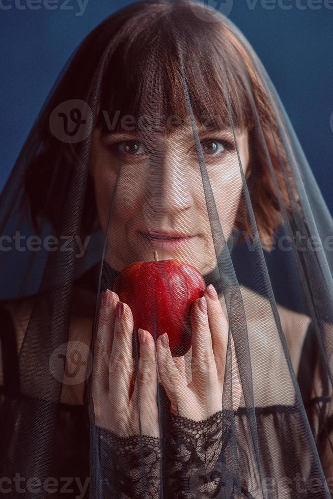 Beautiful woman witch with poison red apple photo