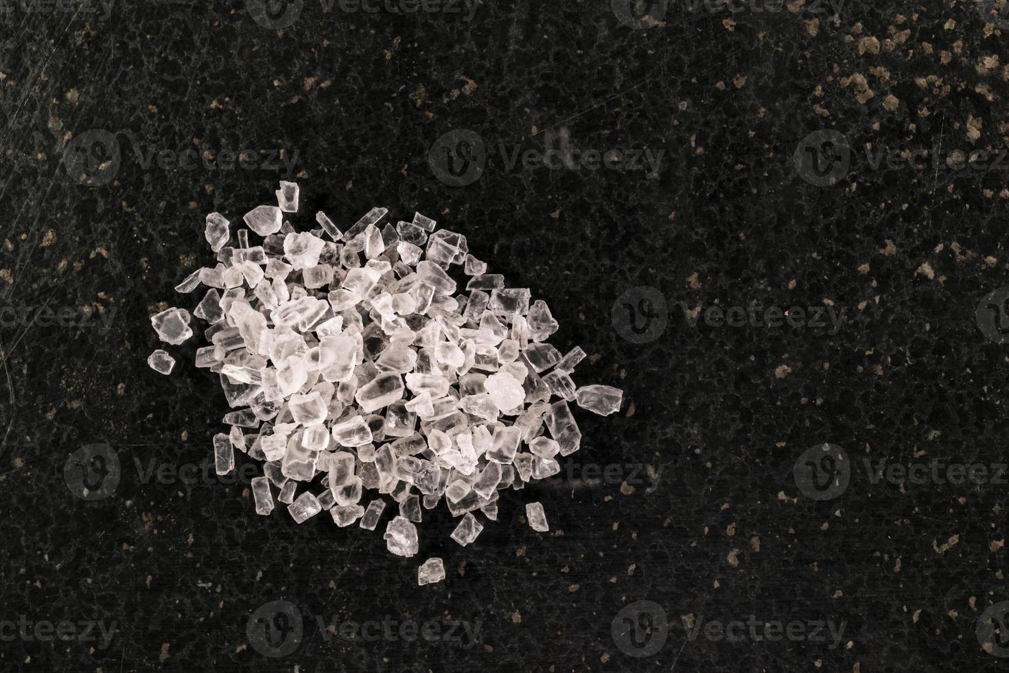 cristales de sal aislados sobre fondo de piedra foto