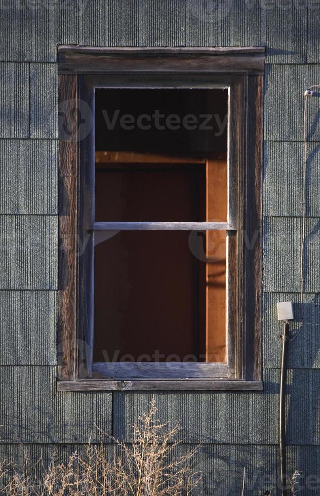 Broken window of old farm house photo