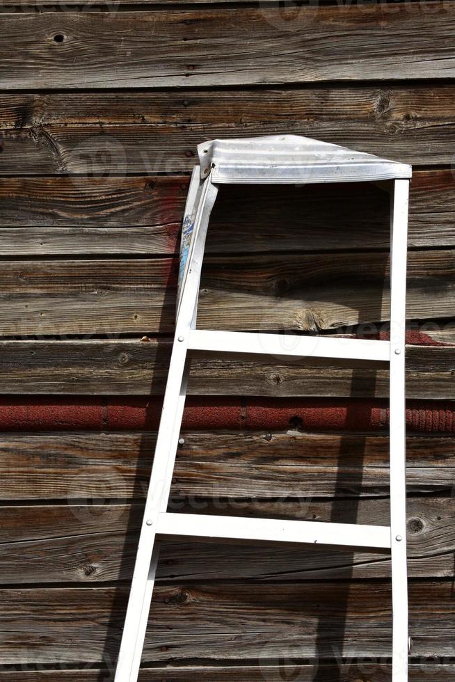 Aluminum ladder against old garage in Saskatchewan photo