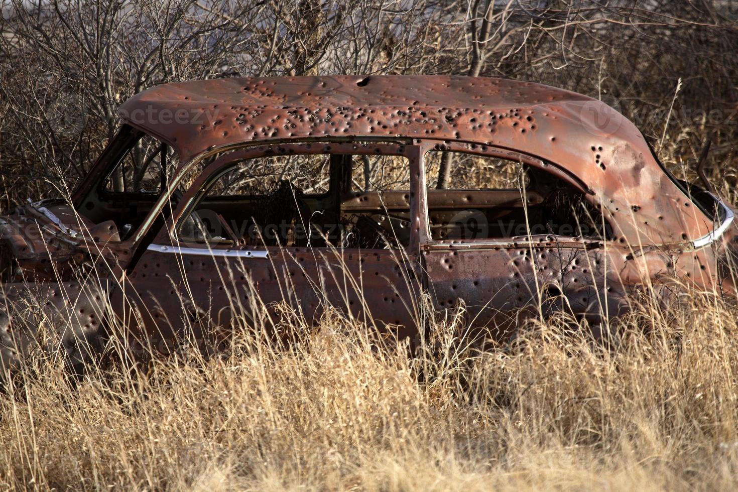 Bullet holes in an abandoned car, photo