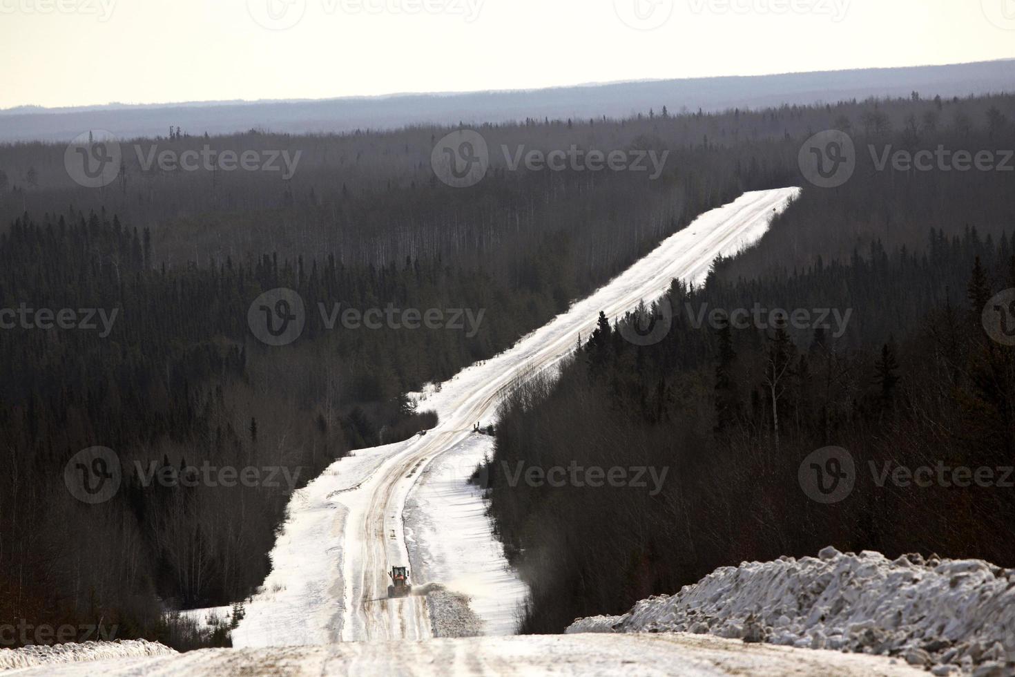 grader at work on logging road in winter photo