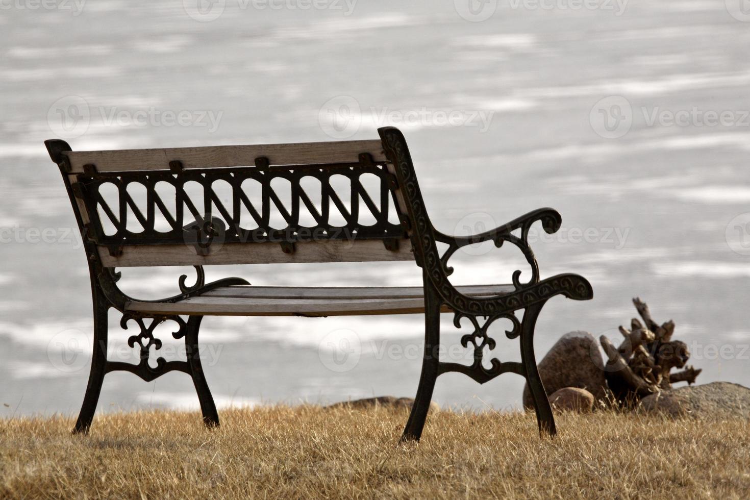 Park bench overlooking frozen lake photo