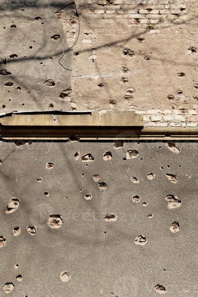 Bullet holes on the facade of a residential building. Stop the war. Armed conflicts. Defund the armies. No to war. photo