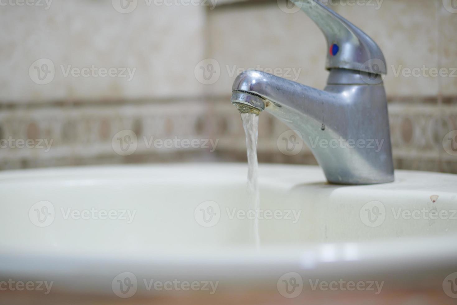 close up of faucet with flowing water photo