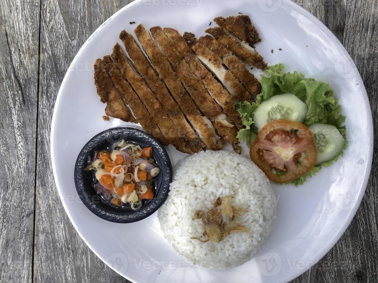 Rice with deep fried chicken and curry in Japanese style or katsu kare in white plate ready to eat. photo