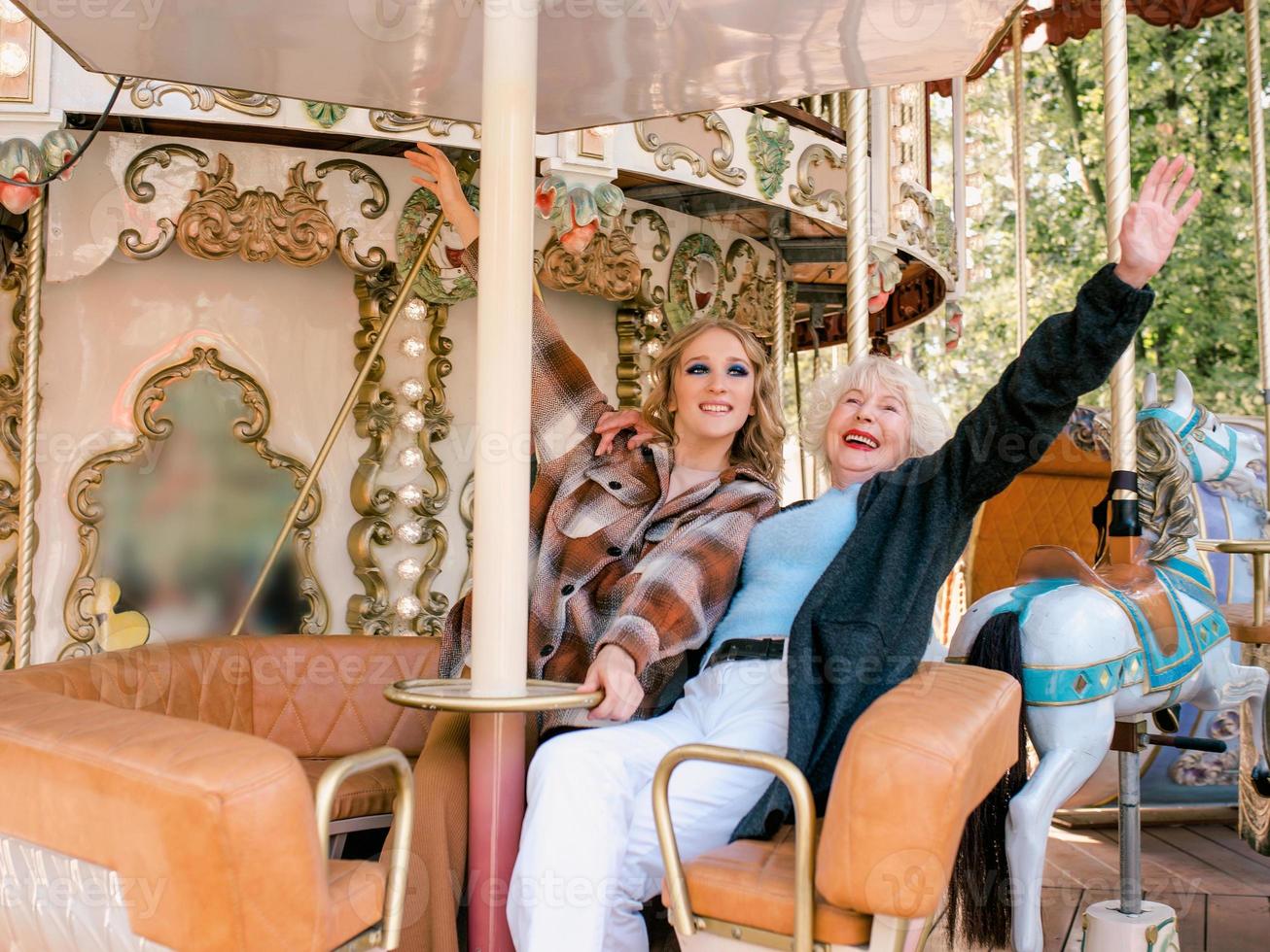 retrato de una anciana con su hija pasando un buen rato juntos en el parque de atracciones. se acabó el encierro, la familia, las relaciones, el cuidado, la vida después de la vacunación, divertirse con el concepto familiar foto