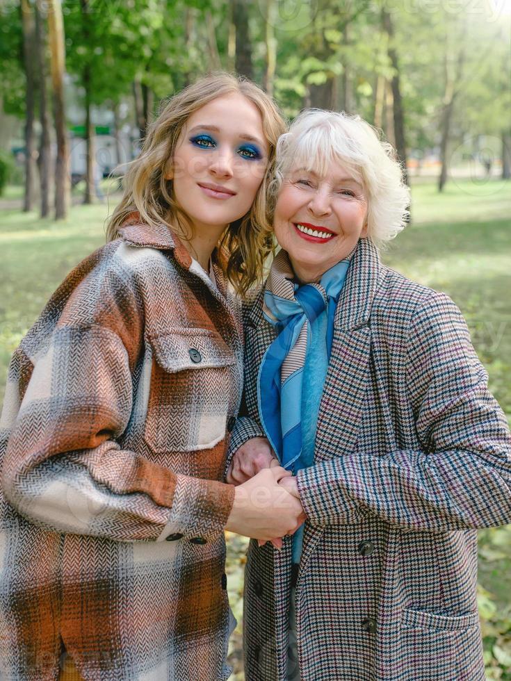 mujer mayor con hija pequeña caminando al aire libre en primavera. familia, generación, cuidado, amor, concepto de vacunación foto