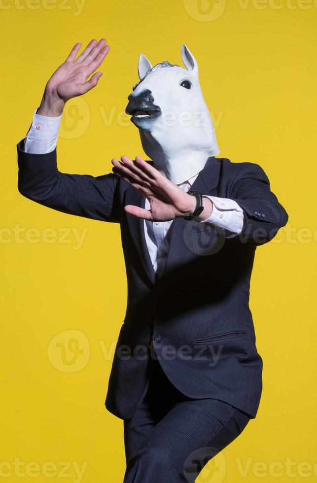 man with horse mask on yellow background photo