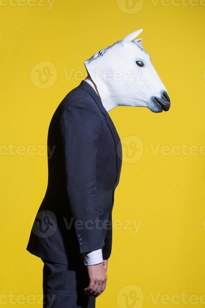 man with horse mask on yellow background photo