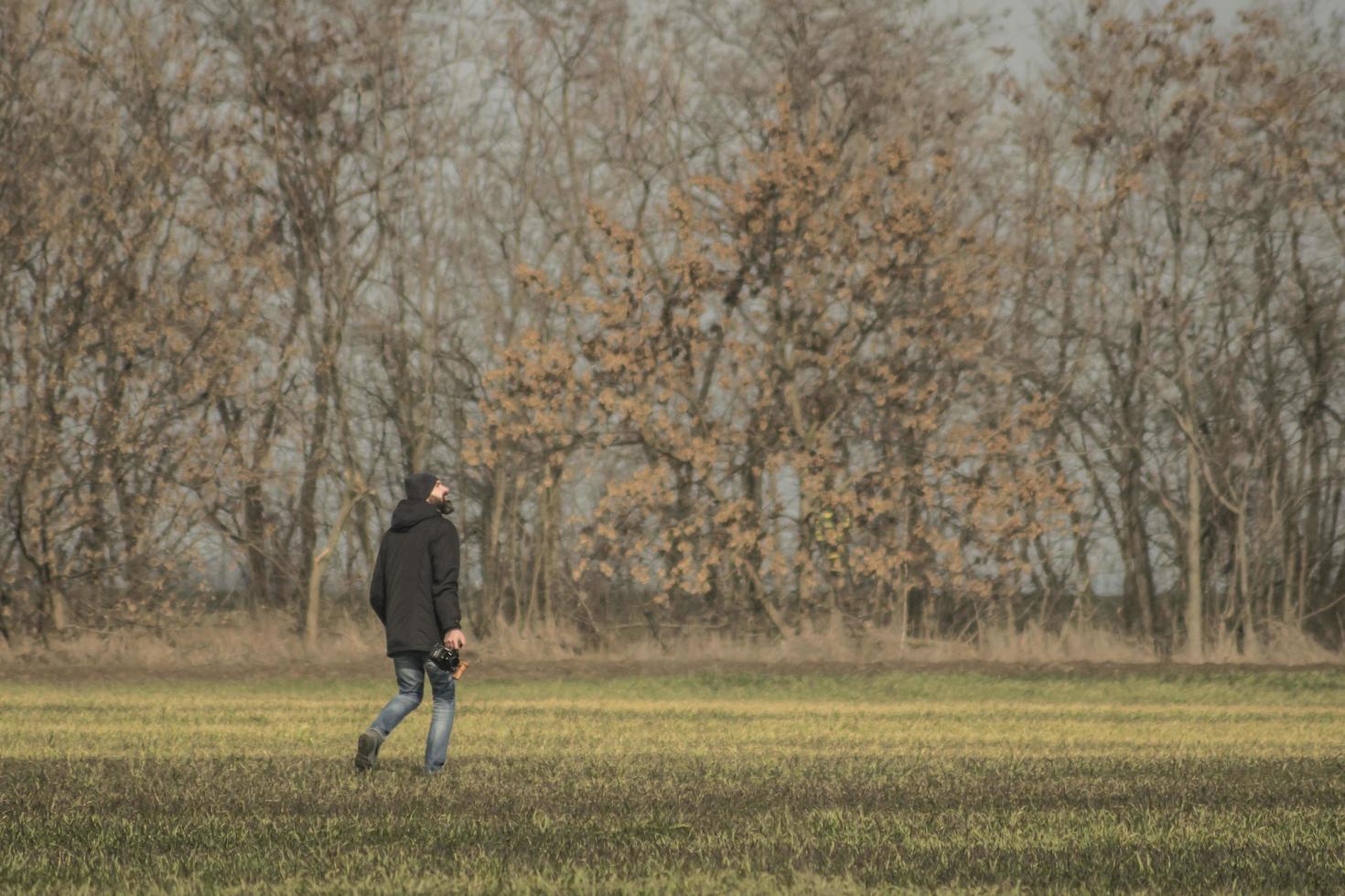 un hombre con una cámara camina por el campo foto