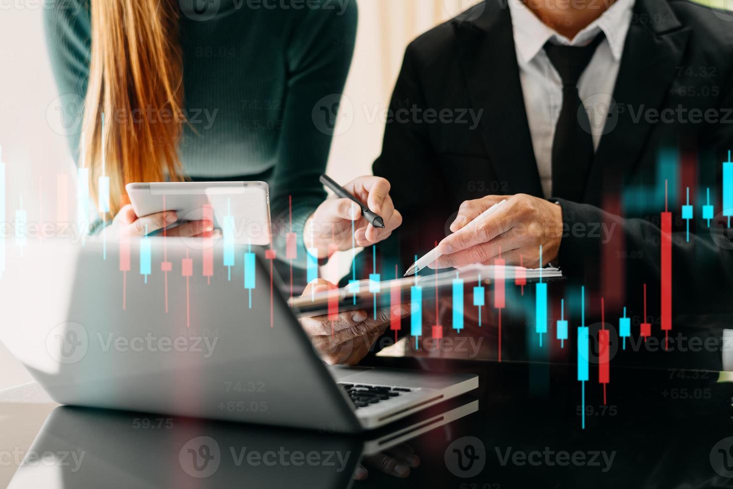 dos traides profesionales en el gráfico e indicador de precios técnicos, el gráfico de velas rojas y verdes y la computadora de negociación de acciones foto