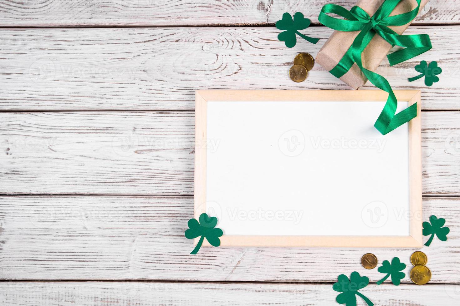 Happy St. Patrick's Day concept. Clover shamrock, gold coins and a gift with a green ribbon on a white background. photo