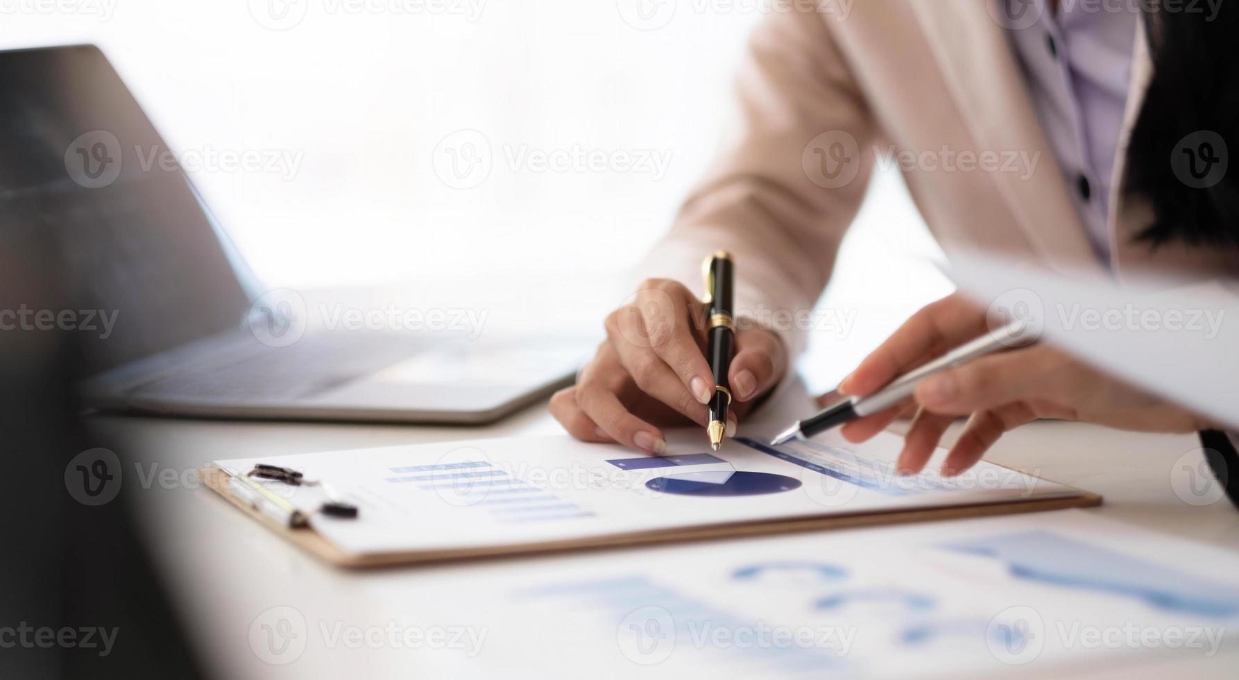 Close up business people meeting to find analytical ideas pointing to the graph at the office. photo