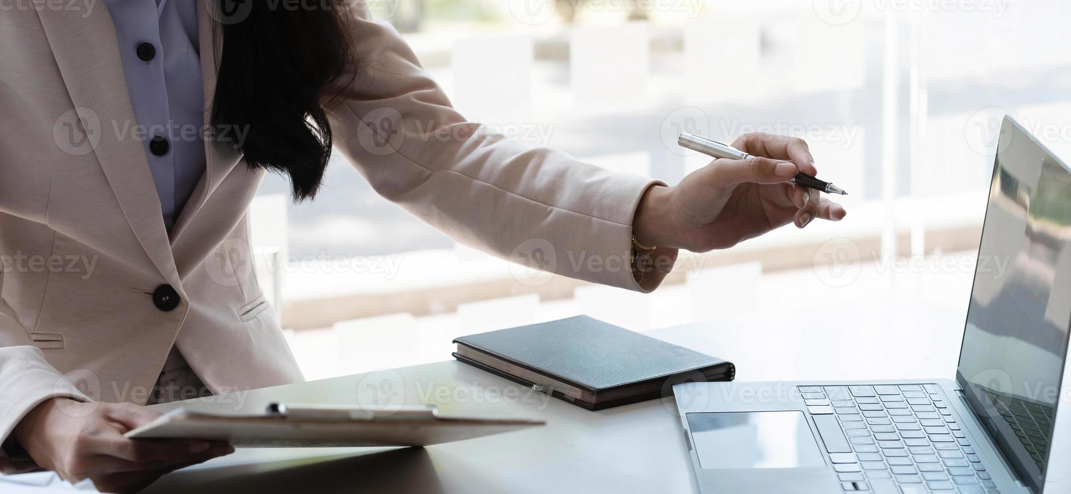 businesswoman working pointing laptop computer and discussing documents and idea. photo