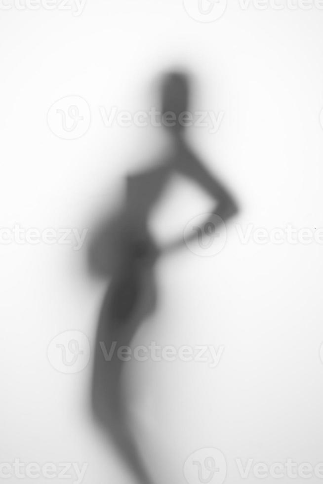 silueta de una mujer embarazada sobre un fondo claro foto