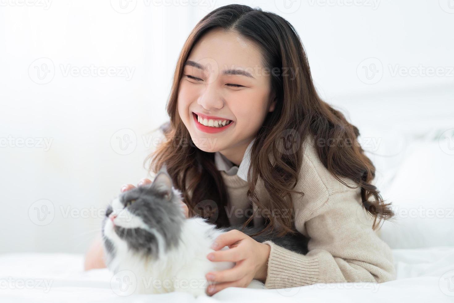 Young Asian woman playing with cat at home photo
