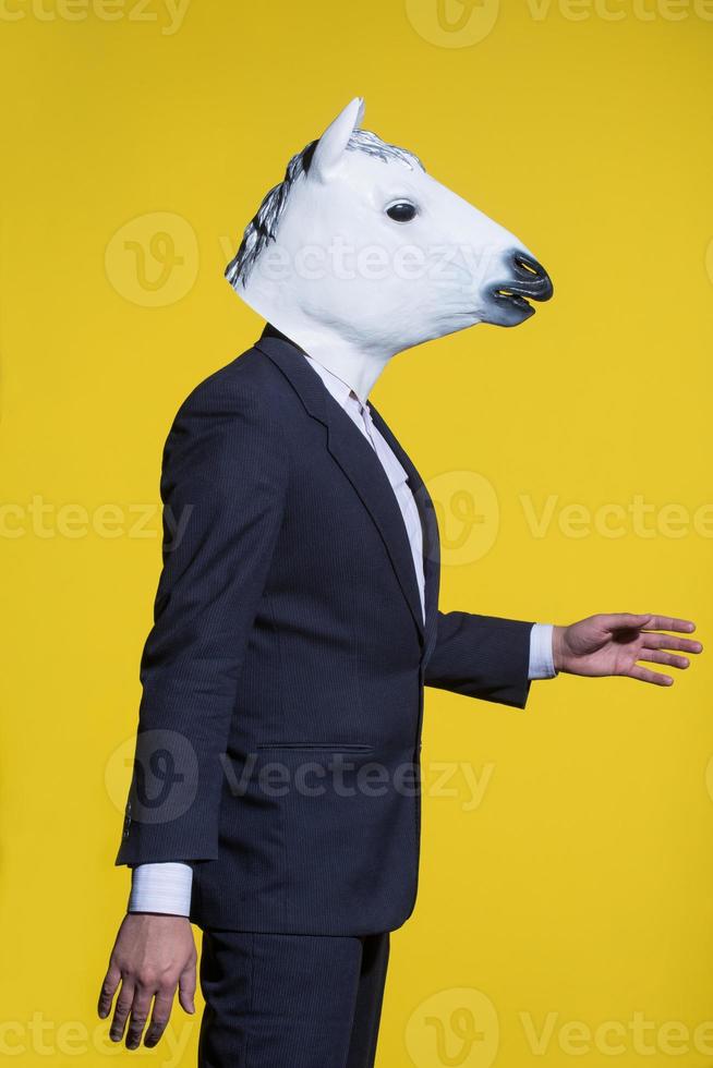 man with horse mask on yellow background photo