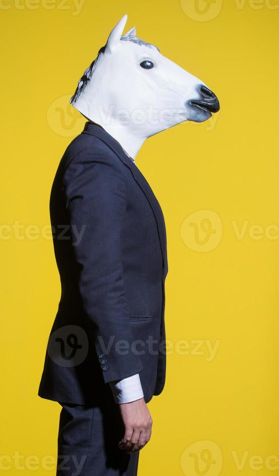 man with horse mask on yellow background photo