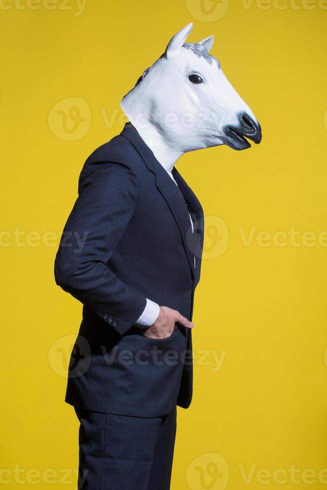 hombre con máscara de caballo sobre fondo amarillo foto