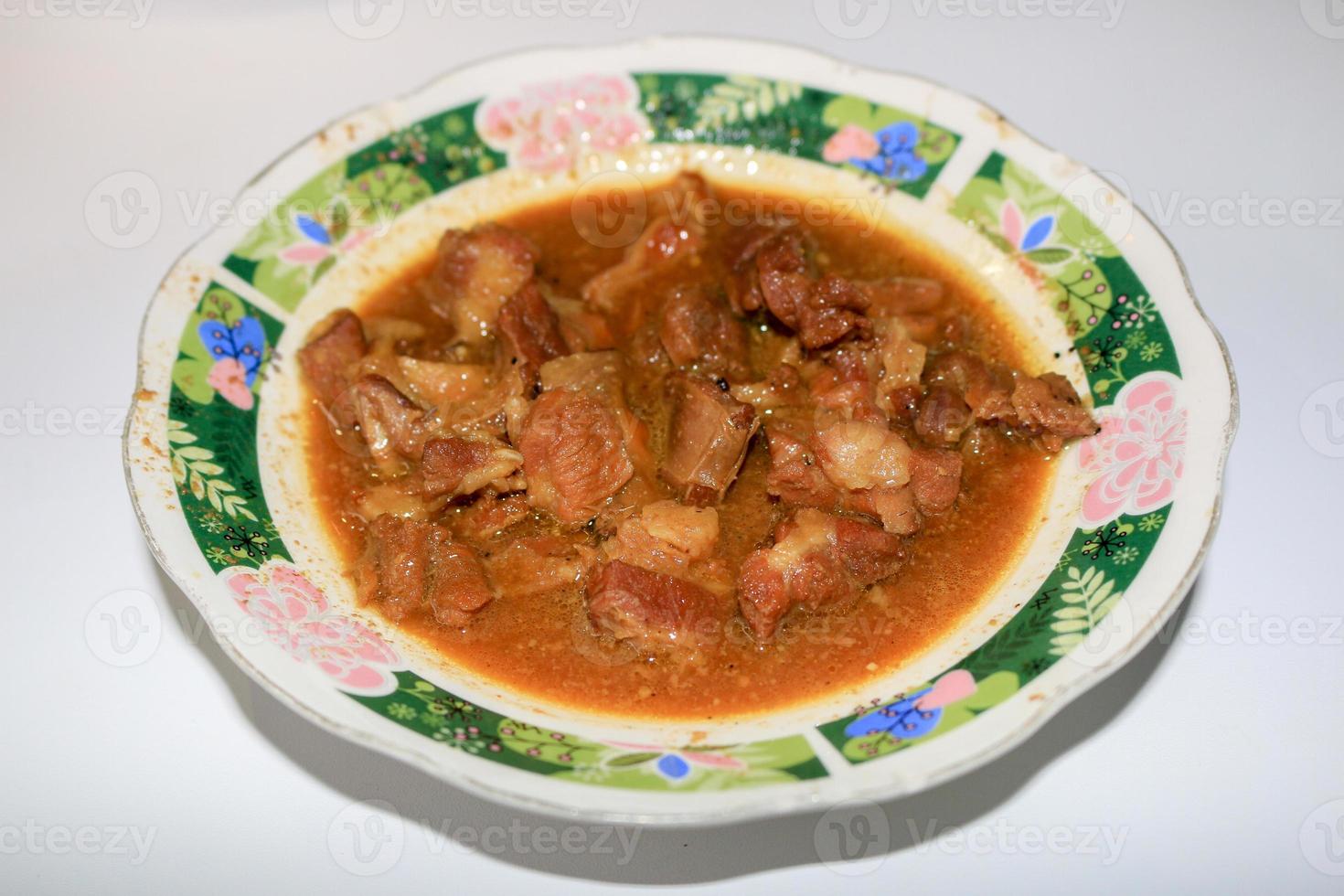 meat with yellow curry or Tongseng in plate. Tongseng is traditional food from central java indonesia photo
