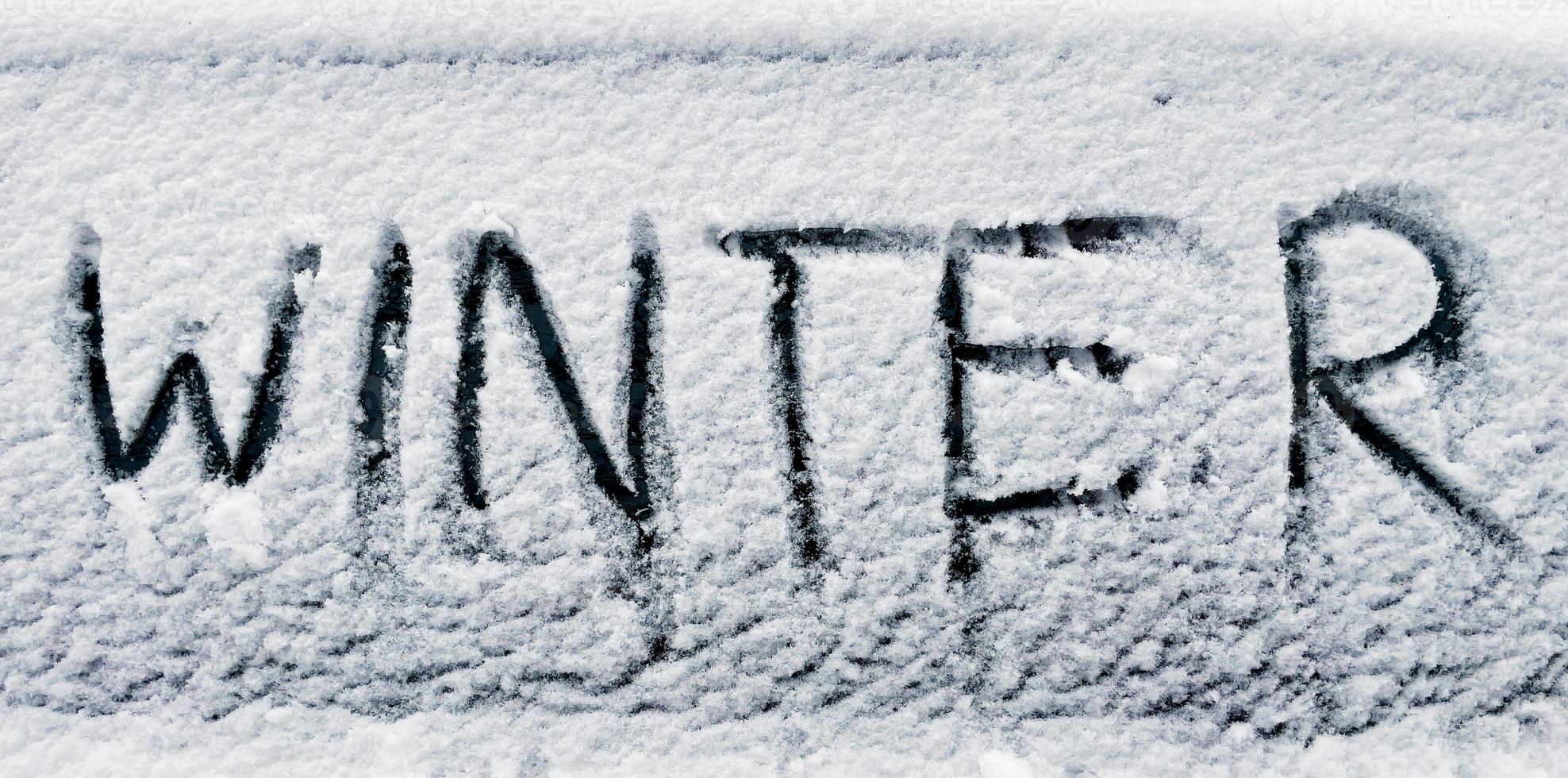 winter written in snow on car window photo