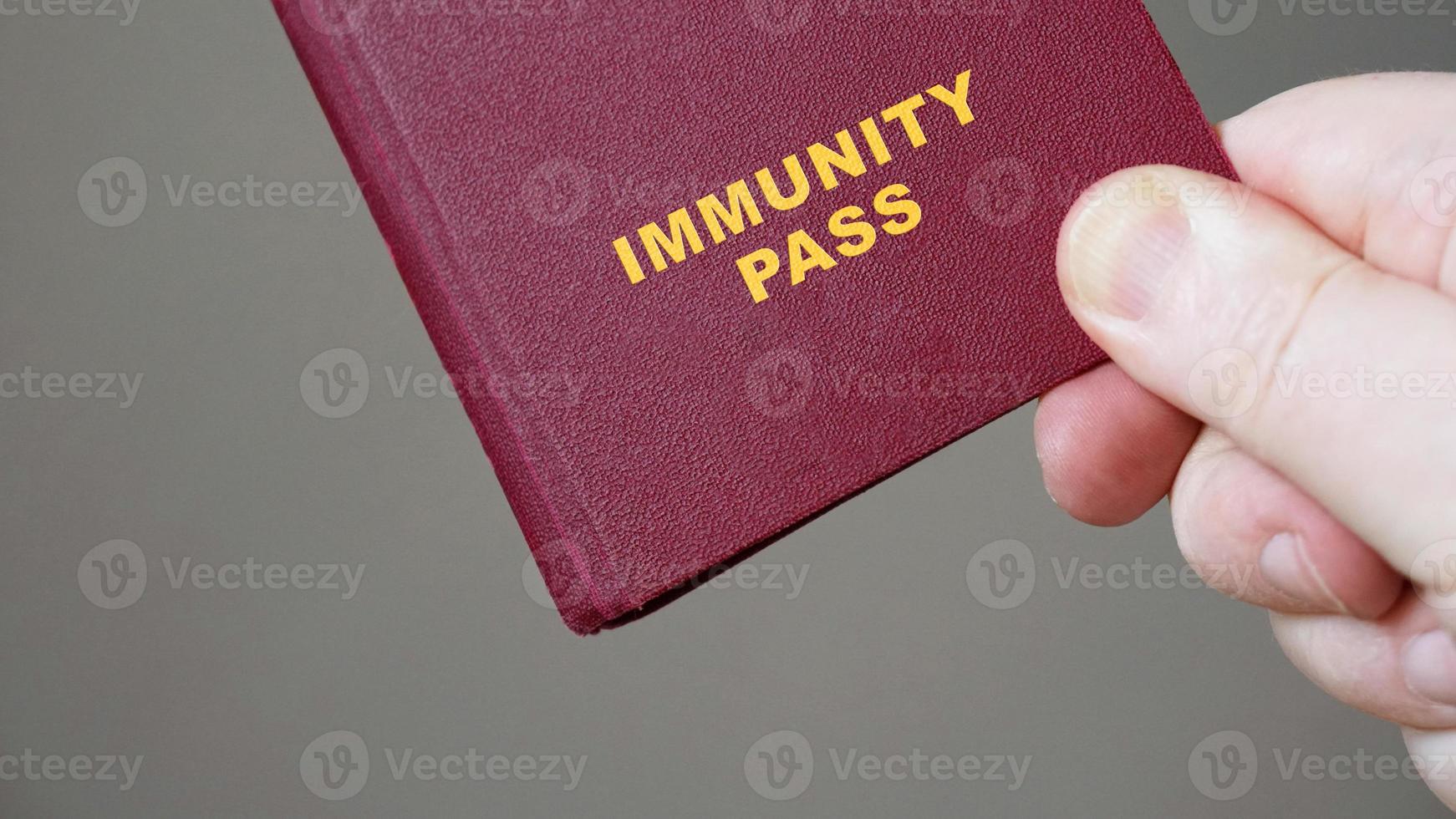 pase de inmunidad o pasaporte - mano que sostiene el documento de viaje del certificado de inmunidad europeo simulado foto