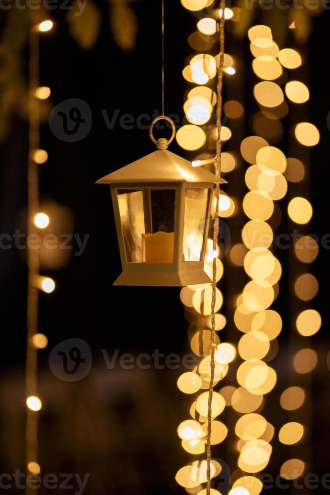 burning candles on a dark night in a wooden lantern photo