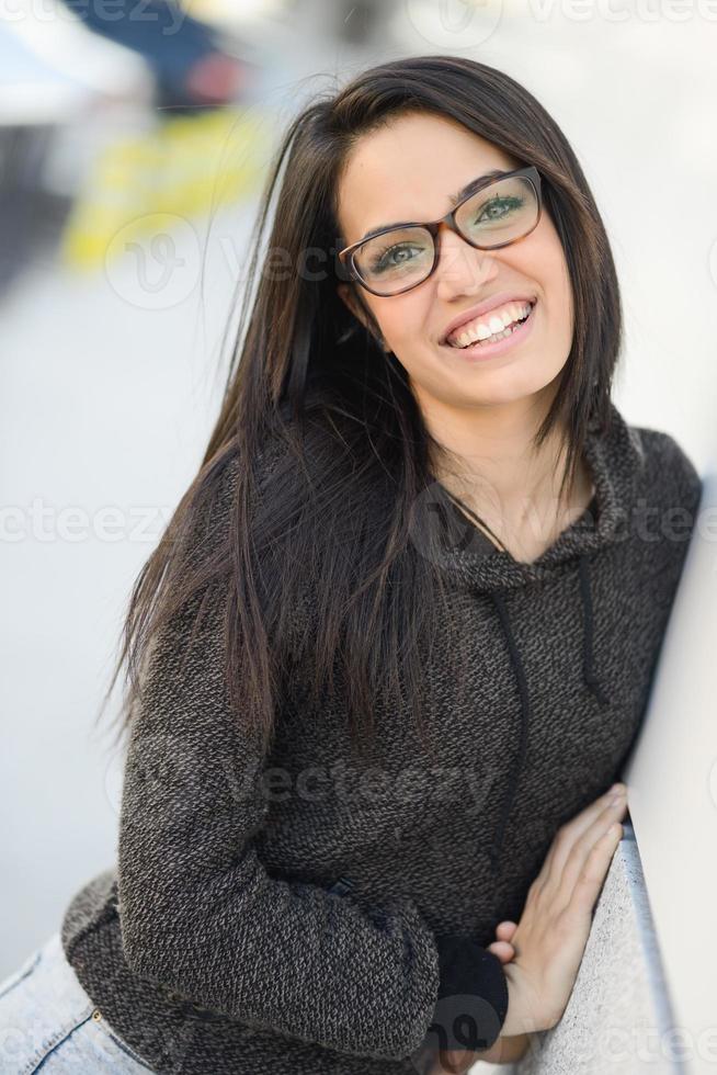 mujer joven con ojos verdes y anteojos de fondo urbano foto