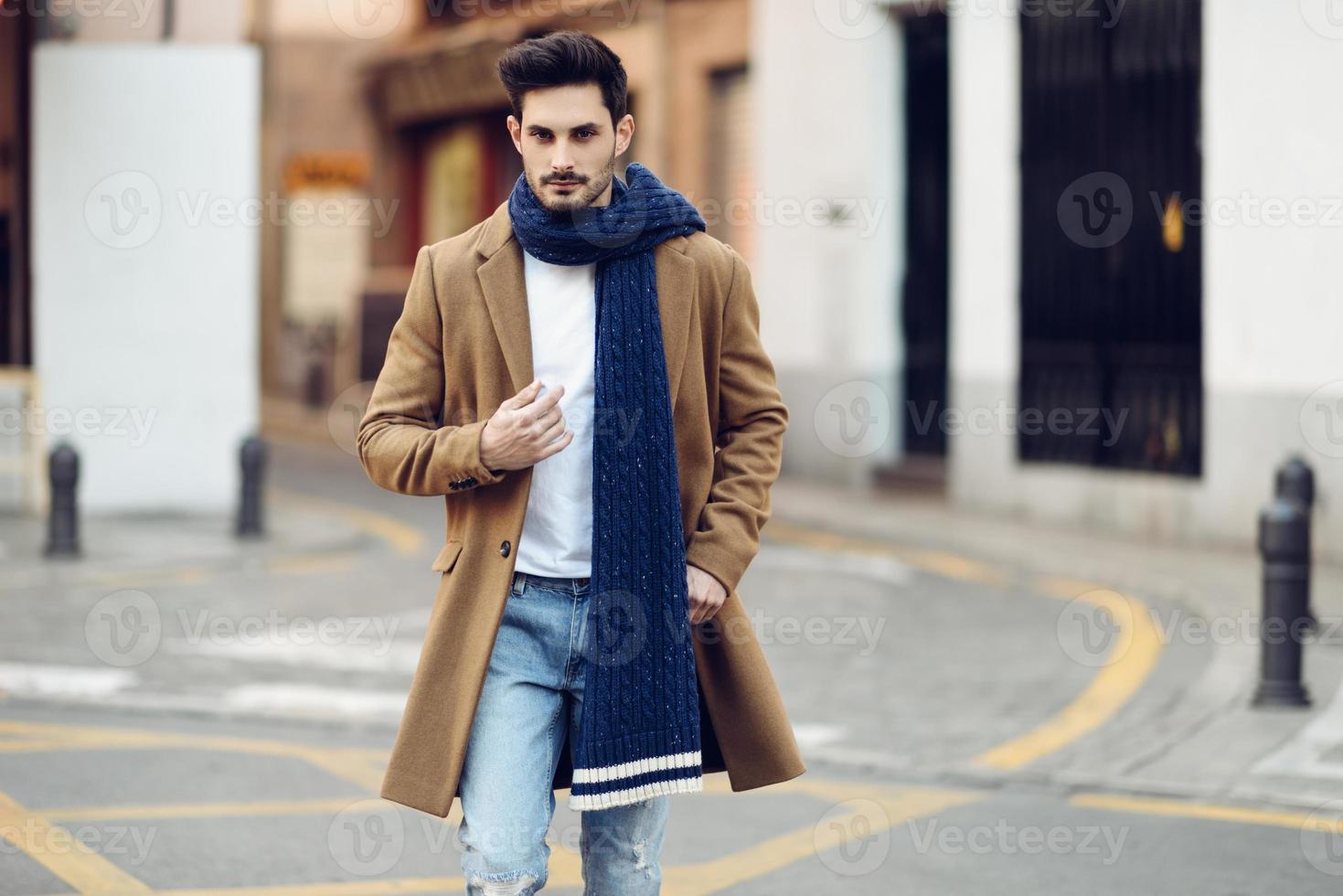 Young man wearing winter clothes in the street. photo