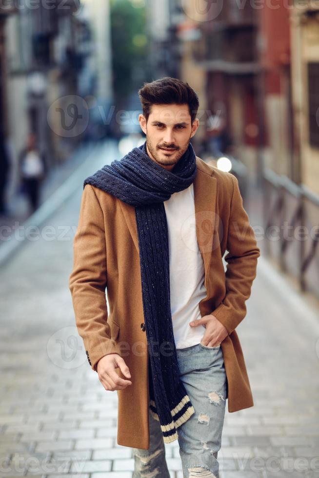 Young man wearing winter clothes in the street. photo