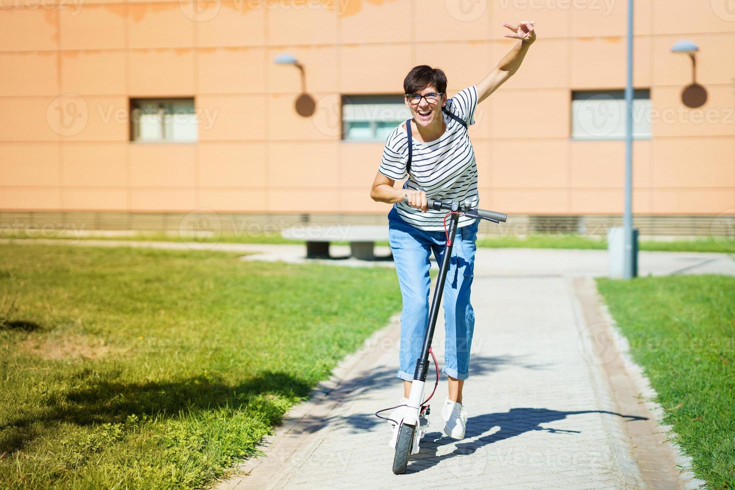 Woman riding around town on an electric scooter photo