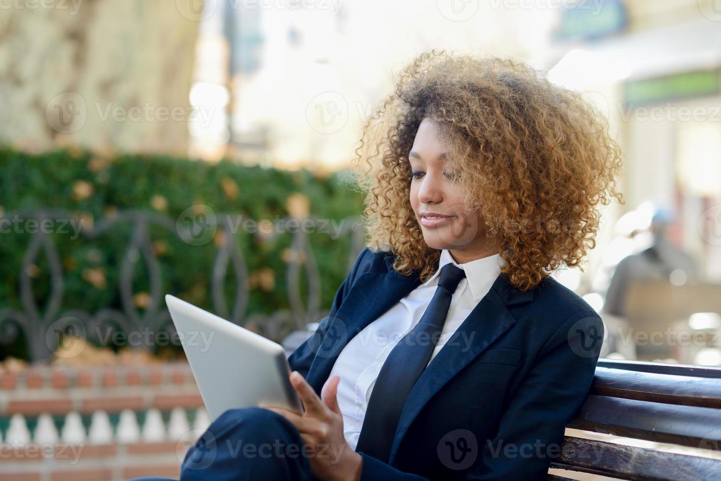 mujer negra usando una tableta en la ciudad foto